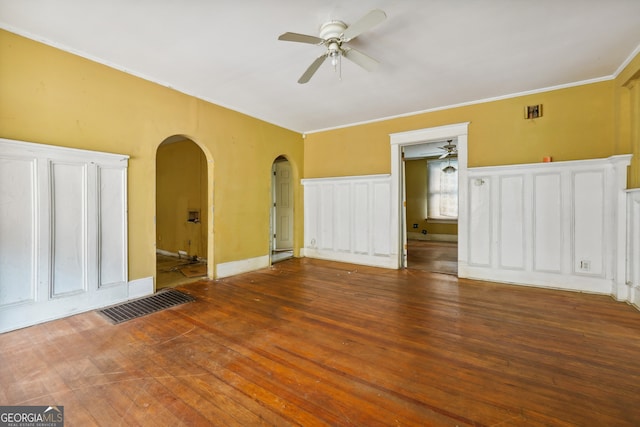 empty room with wood-type flooring, ceiling fan, and ornamental molding