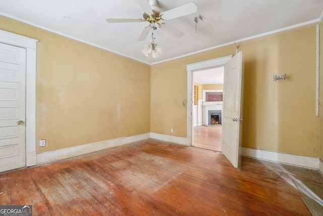 unfurnished room featuring ceiling fan, wood-type flooring, and ornamental molding