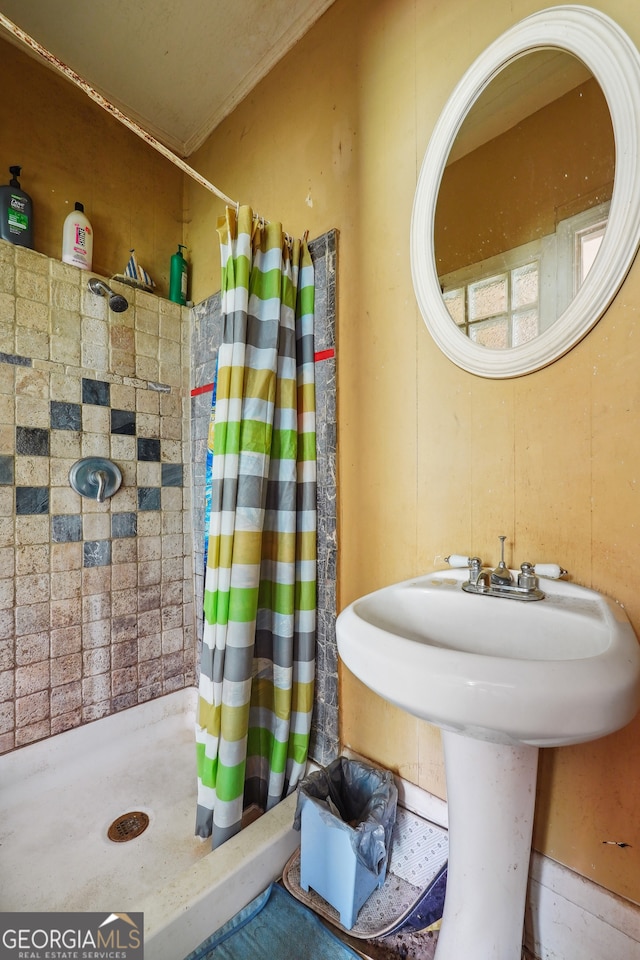 bathroom with curtained shower, ornamental molding, and sink