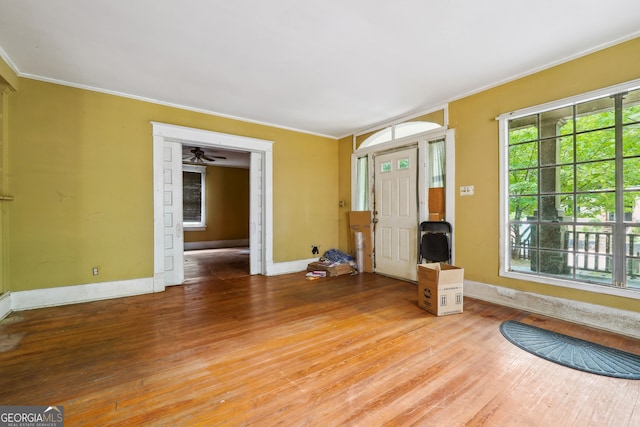 unfurnished living room featuring hardwood / wood-style flooring, ceiling fan, and ornamental molding