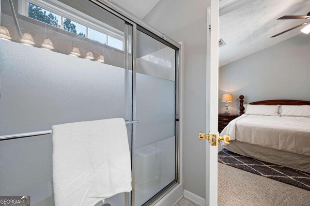 bathroom featuring ceiling fan and a shower with shower door