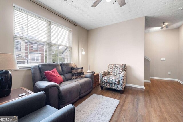 living room with hardwood / wood-style floors, a textured ceiling, and ceiling fan