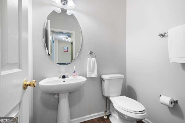 bathroom featuring hardwood / wood-style flooring and toilet