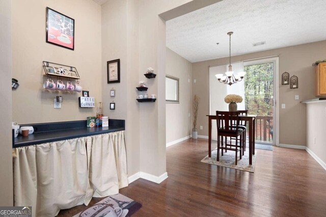 interior space with a chandelier, dark wood-type flooring, and a textured ceiling