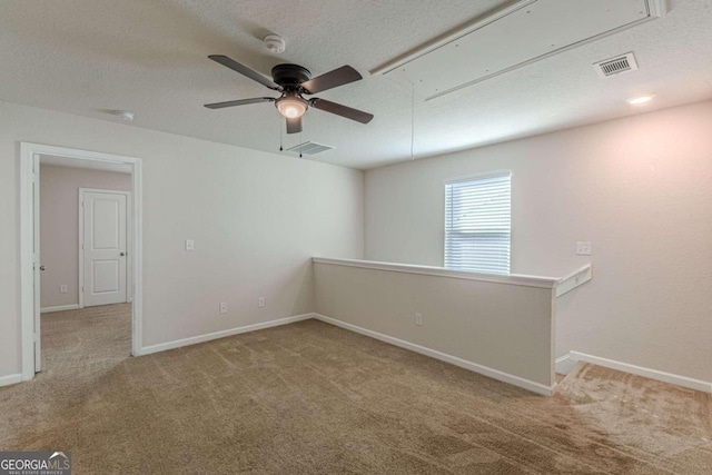 carpeted spare room with ceiling fan and a textured ceiling