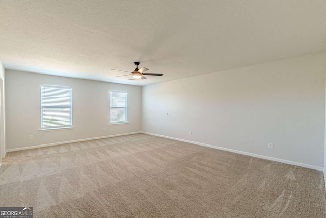 carpeted spare room featuring ceiling fan and a textured ceiling