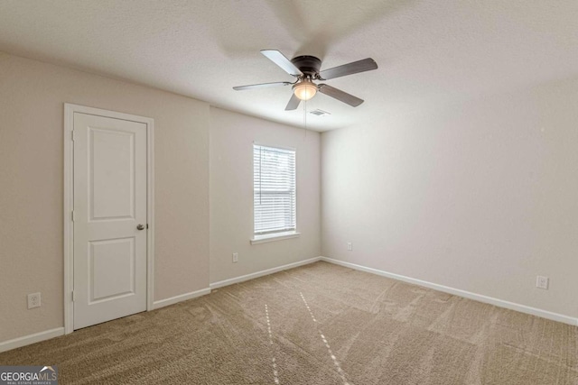 spare room featuring ceiling fan and carpet