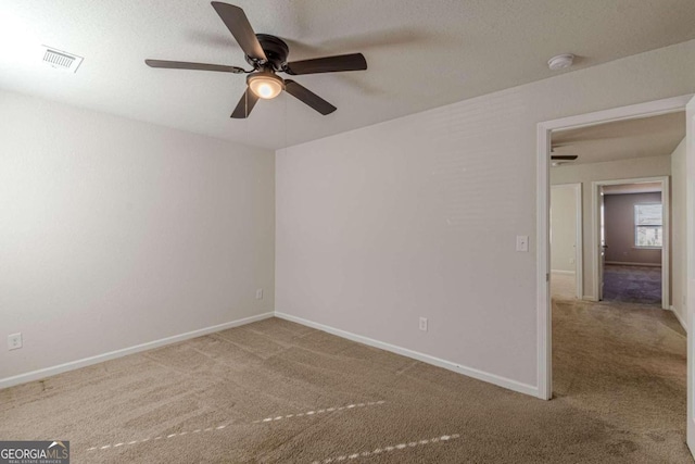 carpeted empty room featuring ceiling fan