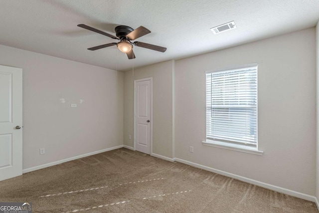 spare room featuring carpet, a textured ceiling, and ceiling fan