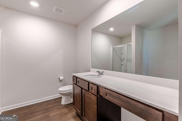 bathroom featuring hardwood / wood-style floors, vanity, toilet, and walk in shower