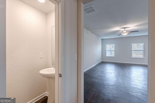 bathroom with ceiling fan and a textured ceiling