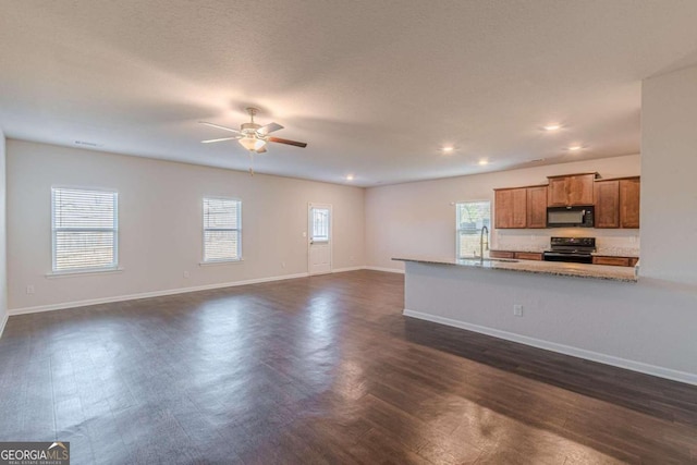 kitchen with dark hardwood / wood-style floors, a wealth of natural light, and black appliances