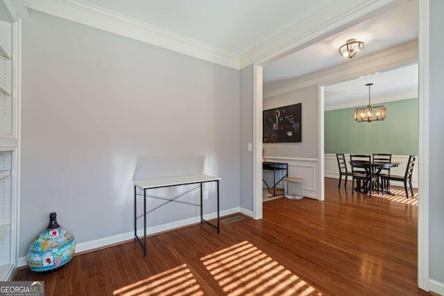 sitting room featuring dark hardwood / wood-style floors, an inviting chandelier, and crown molding