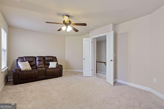 carpeted living room with ceiling fan