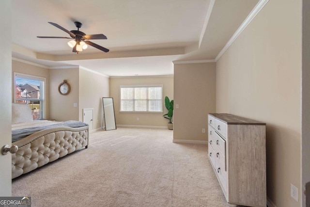 carpeted bedroom featuring a tray ceiling, multiple windows, ceiling fan, and crown molding