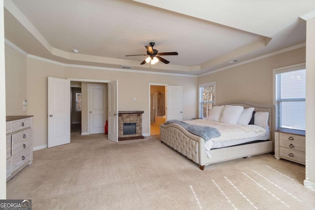 carpeted bedroom featuring ceiling fan, a raised ceiling, and crown molding