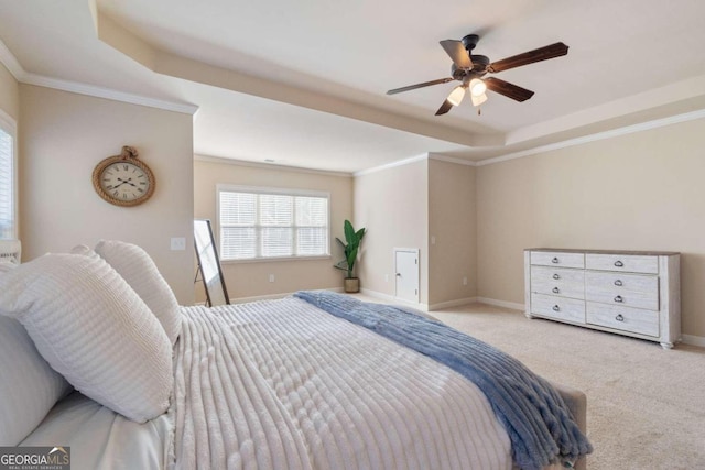 bedroom with a raised ceiling, crown molding, ceiling fan, and light carpet