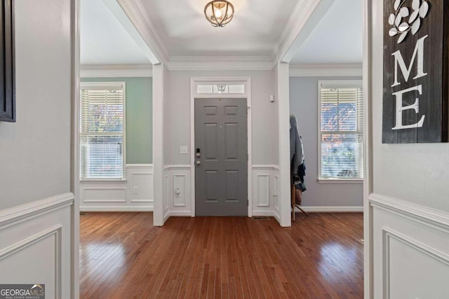 entrance foyer with hardwood / wood-style flooring and crown molding