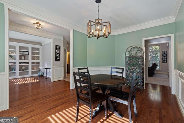 dining area featuring dark hardwood / wood-style flooring, an inviting chandelier, and ornamental molding