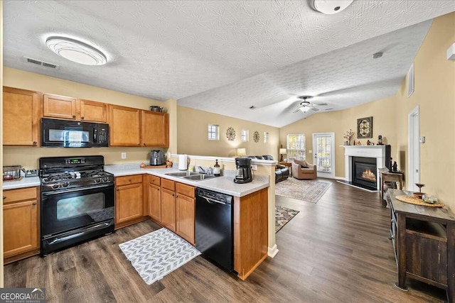 kitchen with kitchen peninsula, dark hardwood / wood-style flooring, a textured ceiling, black appliances, and lofted ceiling