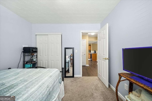 carpeted bedroom featuring a textured ceiling and a closet