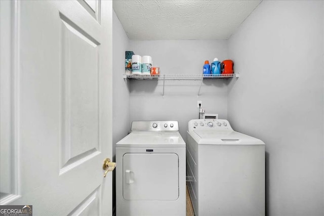 washroom featuring a textured ceiling and washer and clothes dryer