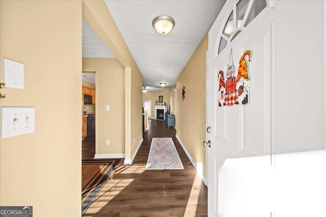 hall with a textured ceiling and dark hardwood / wood-style flooring