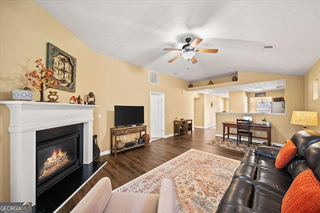 living room with a textured ceiling, ceiling fan, dark wood-type flooring, and lofted ceiling