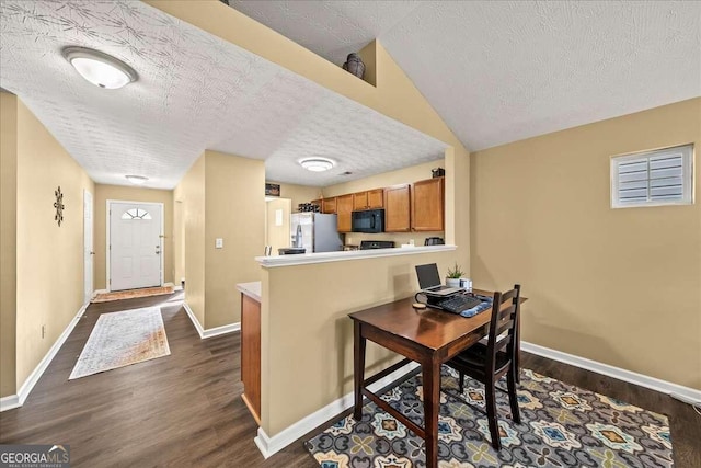 kitchen with a kitchen breakfast bar, dark hardwood / wood-style floors, kitchen peninsula, stainless steel fridge, and a textured ceiling