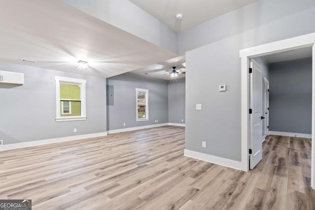 spare room with ceiling fan, light wood-type flooring, and electric panel