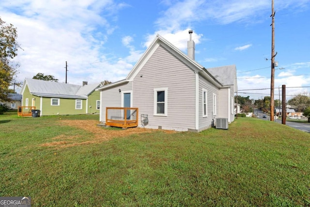 back of house with a lawn and cooling unit