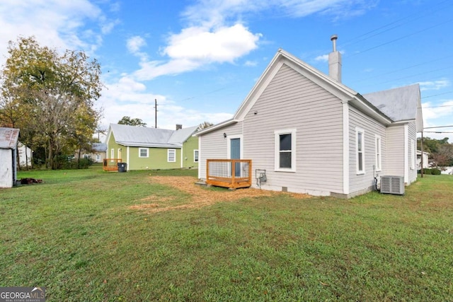 back of house with an outbuilding, central AC, and a lawn