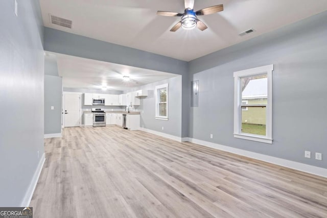 unfurnished living room with ceiling fan and light wood-type flooring