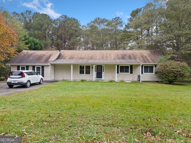 ranch-style home featuring covered porch and a front lawn