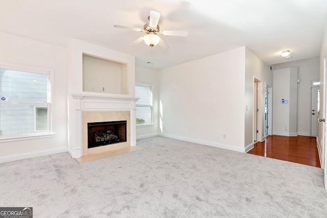 unfurnished living room with carpet and ceiling fan