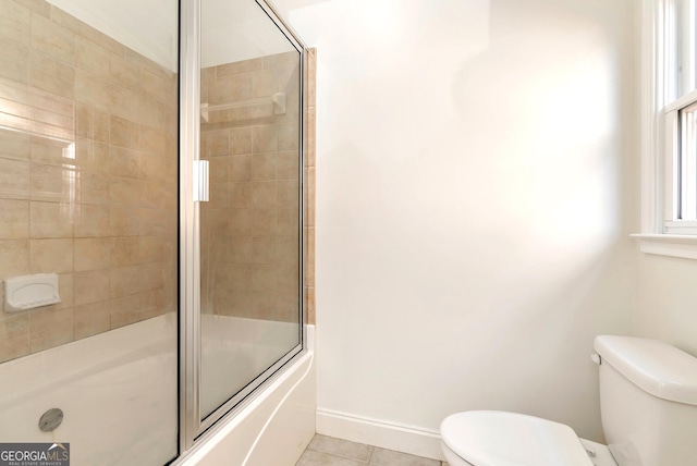 bathroom with tile patterned floors, combined bath / shower with glass door, and toilet