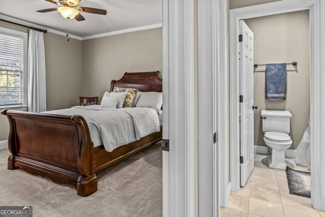 tiled bedroom featuring ceiling fan, crown molding, and ensuite bathroom