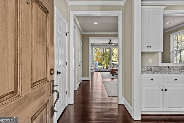 corridor with dark wood-type flooring and ornamental molding