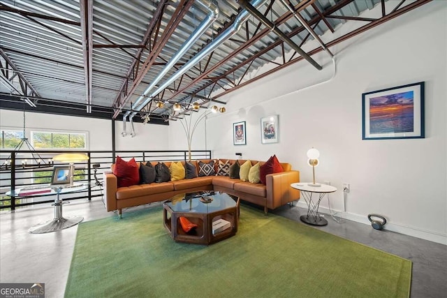 living room featuring a towering ceiling and concrete flooring