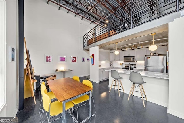 dining space with a towering ceiling and sink