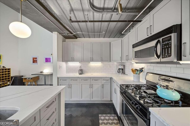 kitchen with pendant lighting, decorative backsplash, stainless steel appliances, and light stone counters