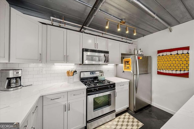 kitchen featuring appliances with stainless steel finishes, light stone countertops, and white cabinets