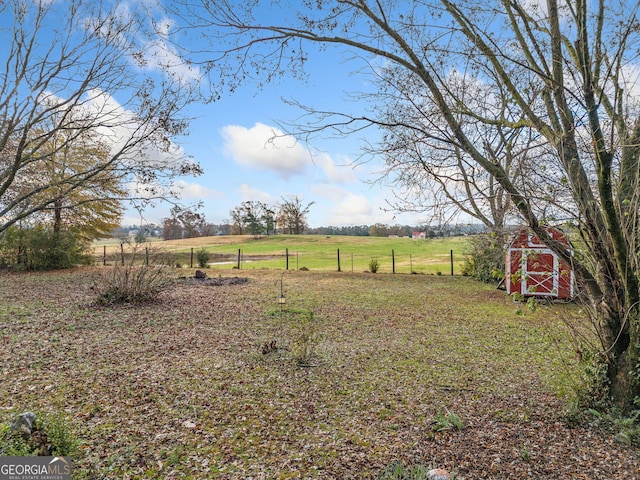 view of yard with a rural view and a shed