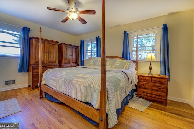 bedroom featuring light hardwood / wood-style flooring, multiple windows, and ceiling fan