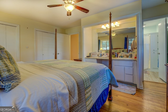 bedroom with ceiling fan, light hardwood / wood-style flooring, and two closets