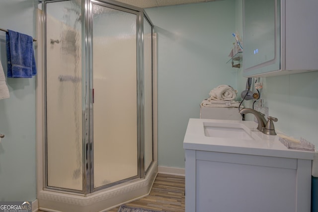 bathroom with vanity, wood-type flooring, and a shower with door