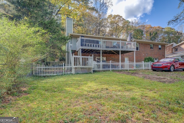 rear view of property featuring a lawn and a wooden deck