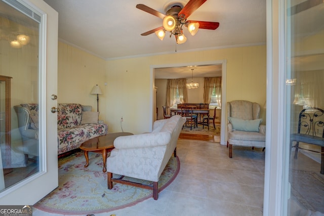 tiled living room featuring ceiling fan with notable chandelier and ornamental molding