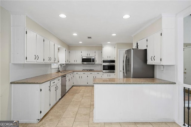 kitchen with light stone counters, sink, white cabinets, and appliances with stainless steel finishes