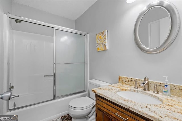 full bathroom featuring combined bath / shower with glass door, toilet, and vanity